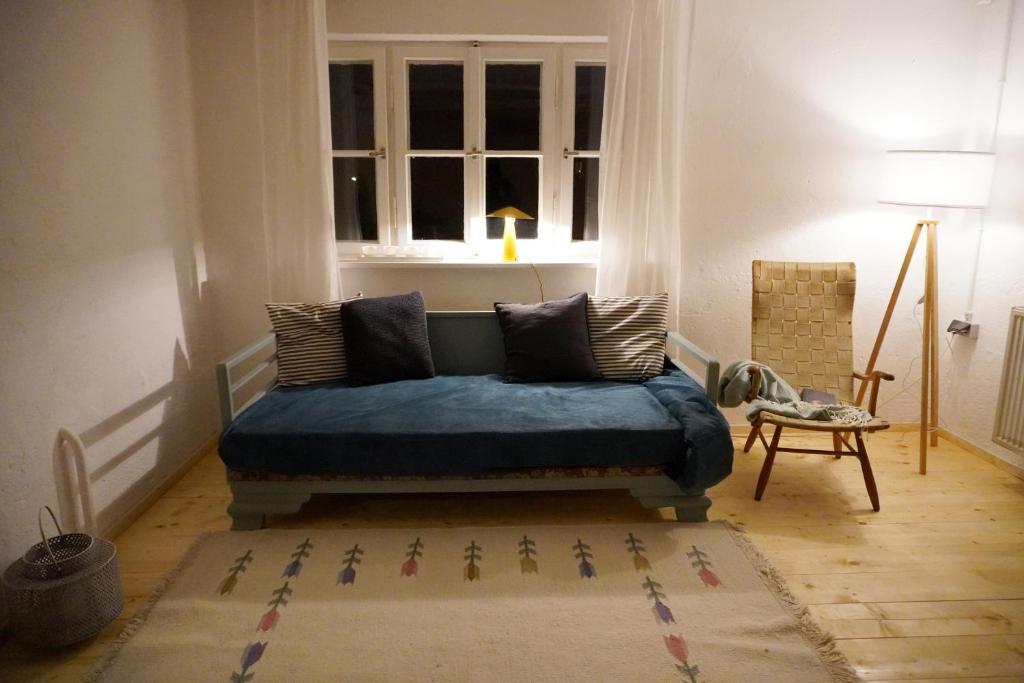a living room with a blue couch in front of a window at Oide Schreinerei in Steingaden