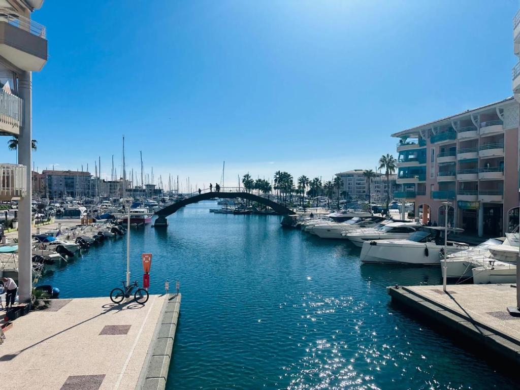 une rivière avec des bateaux dans une marina avec un pont dans l'établissement Résidence le nautica, à Fréjus