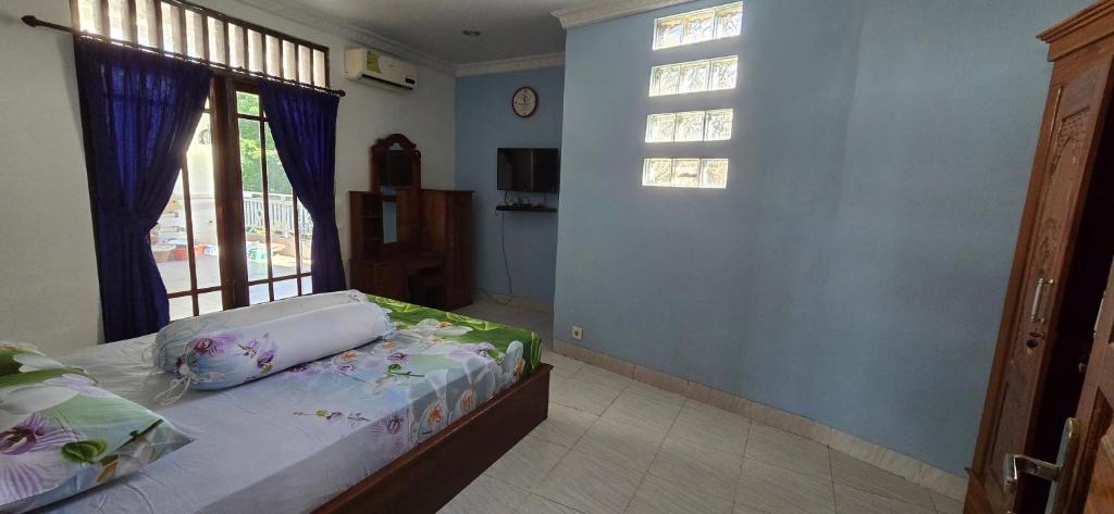 Un dormitorio con una cama y una ventana grande en Devina House, en Kuta