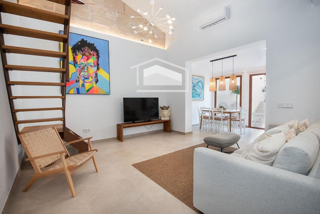 a living room with a white couch and a tv at ElsPeixets Home Mallorca - ArtHouse in Colonia Sant Jordi