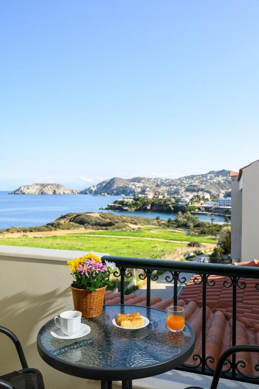 a table on a balcony with a view of the ocean at Psaromoura Residence in Agia Pelagia