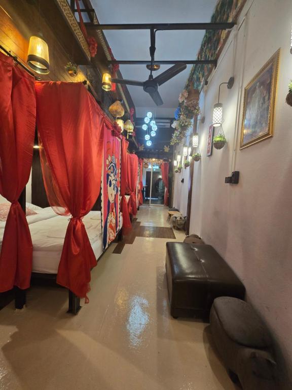 un lungo corridoio con posti letto in una stanza con tende rosse di Little Home in Town a Ban Lo Long