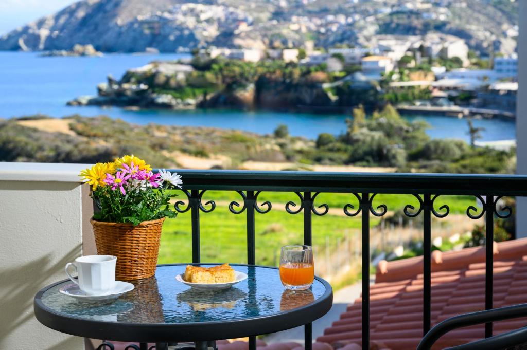 una mesa con una taza de café y un vaso de zumo de naranja en Psaromoura Residence, en Agia Pelagia