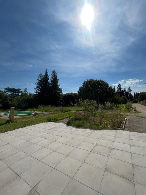 un patio en pierre avec le soleil dans le ciel dans l'établissement Villa Avignon la barthelasse, à Avignon
