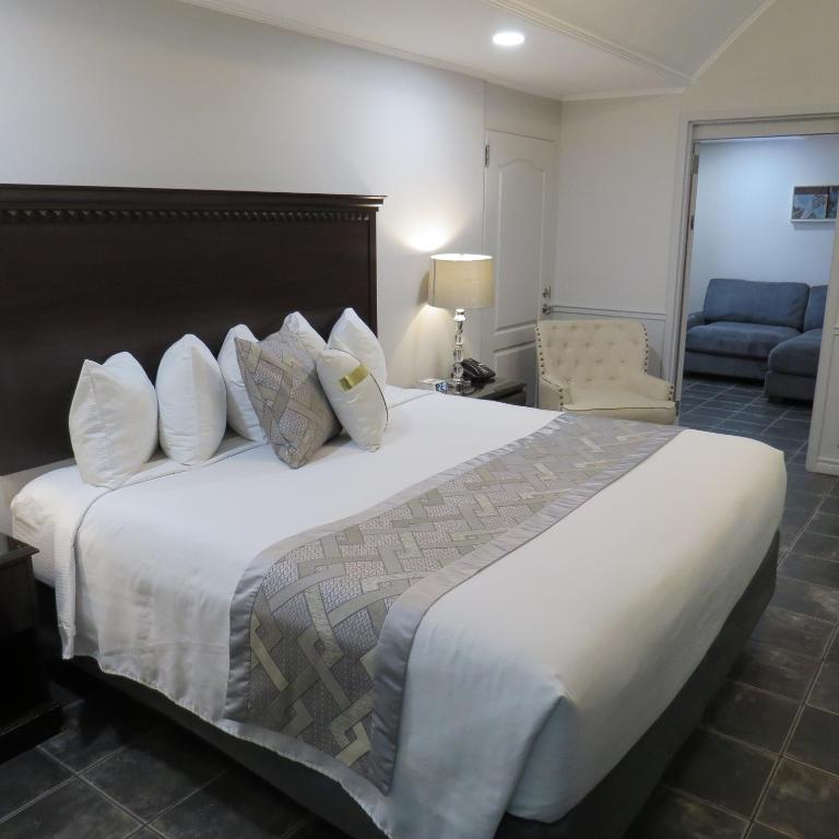 a bedroom with a large bed with white sheets and pillows at Dockside Suites in Digby
