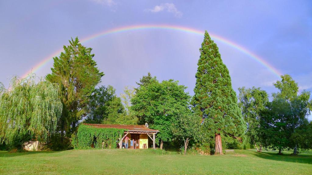 Un arc-en-ciel au-dessus d'une maison dans l'établissement Ferienhaus Chalet Natur und Erholung an der Dordogne, à Payrac