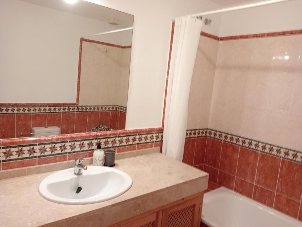 W łazience znajduje się umywalka, wanna i lustro. w obiekcie El Mirador de Estepona w mieście Estepona