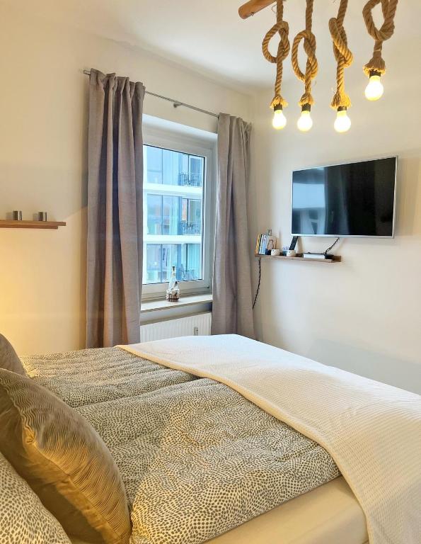 a bedroom with a large bed and a window at See-Hase in Grömitz