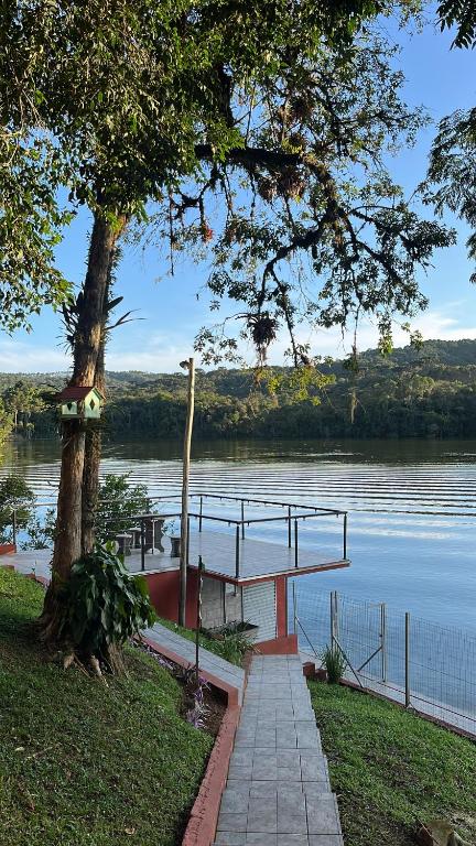 a dock on a lake with a boat in the water at Casa Tangerina - Lago Pinhal in Rio dos Cedros