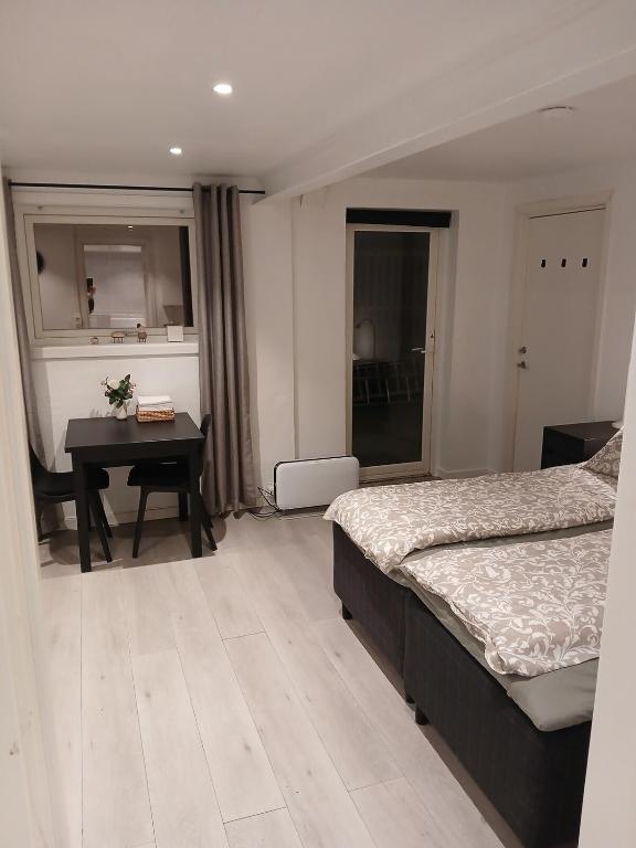 a bedroom with two beds and a table and a desk at studio apartment 24 sqm in Trondheim