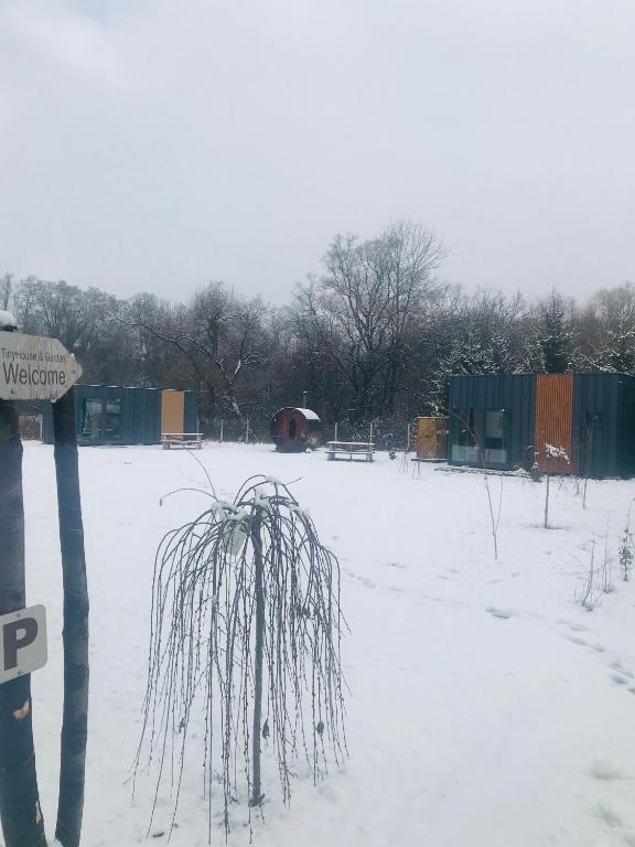 a field covered in snow withsheds in the background at TinyHouses & Garden in Oravská Poruba