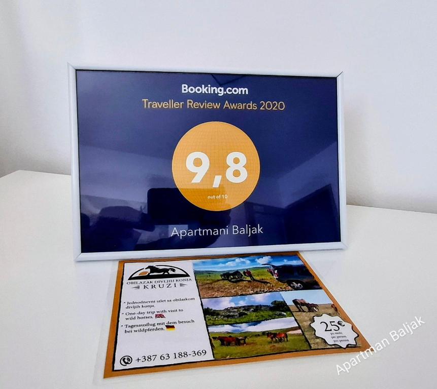 a sign that is on a wall next to a book at Apartman Baljak in Livno