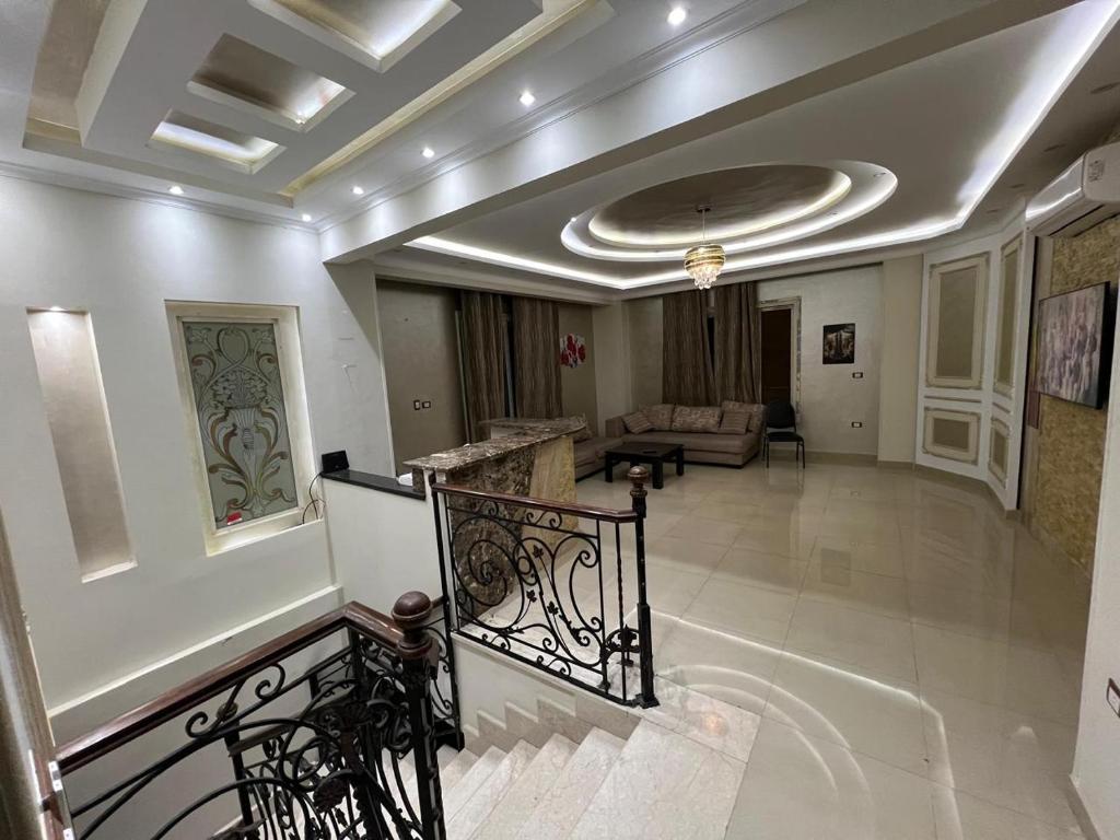 um átrio com uma escada e uma sala de estar em Duplex for rent in Choueifat, Fifth Settlement em Cairo