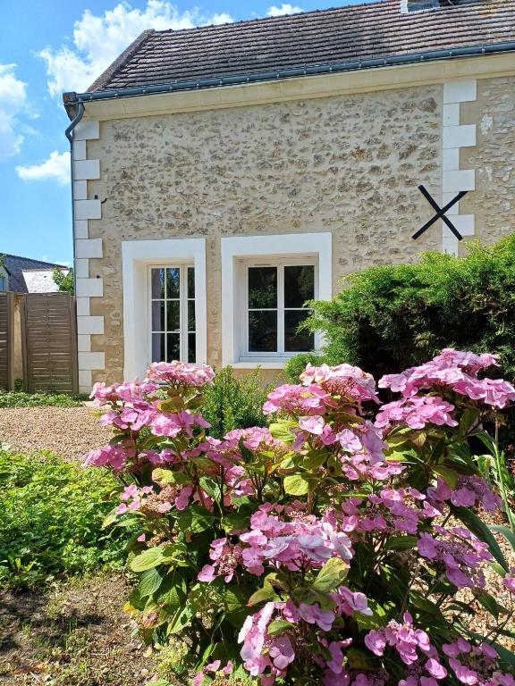 une maison avec des fleurs roses devant elle dans l'établissement Clos de Rosnay, à Saint-Avertin