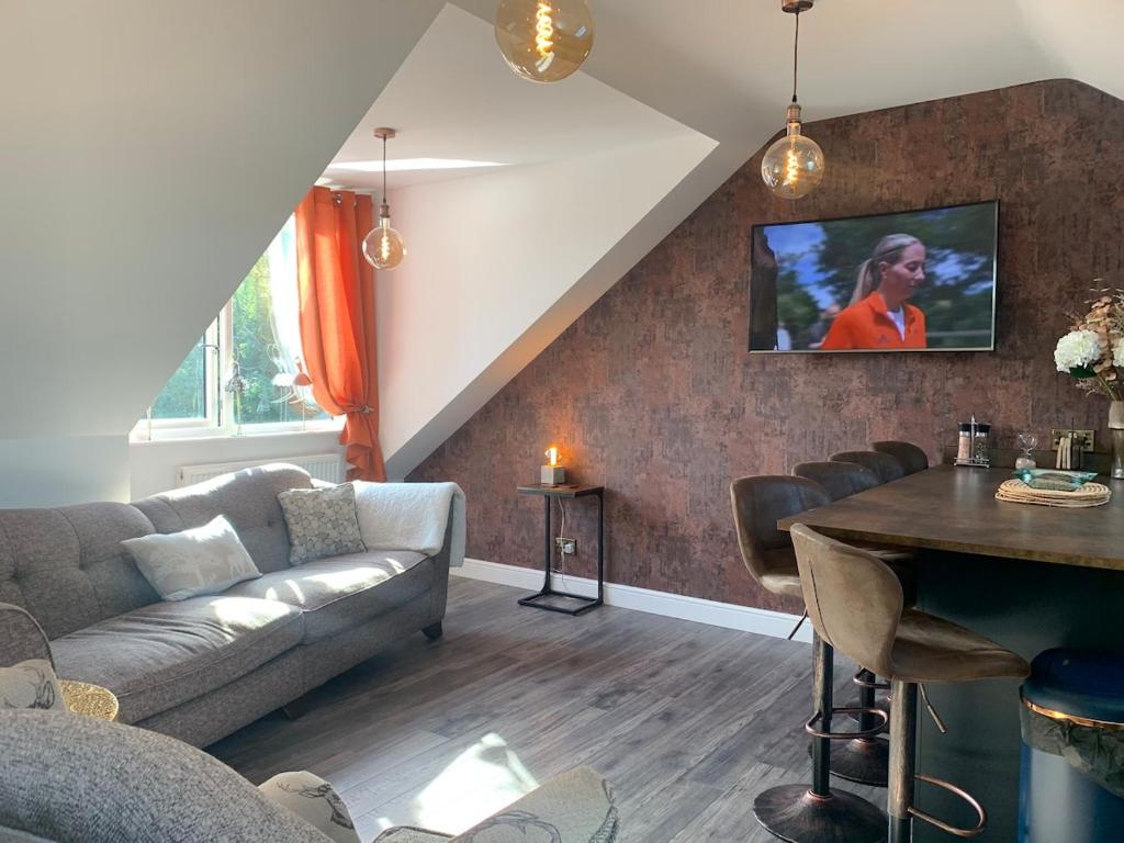 a living room with a couch and a table at Cannons Loft Central Buxton, Duplex loft 3 bedroom Set over 3 floors stairs no lift sleeps 5 in Buxton