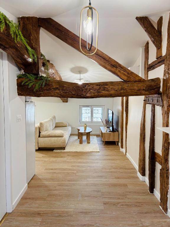 un salon avec parquet et plafond avec poutres dans l'établissement LE C0C00NING - Centre ville, à Marmande