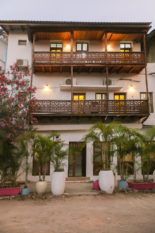 a building with a balcony and plants in front of it at Zanzibar Town Nest Hotel in Zanzibar City