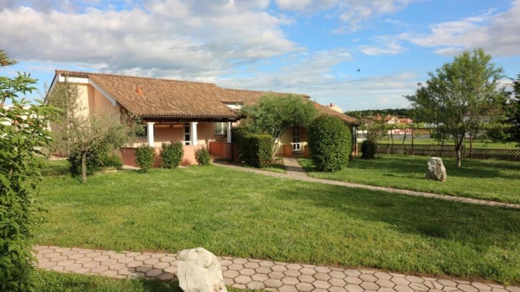 a house with a green yard in front of it at Bungalow Melisa 8 in Poreč