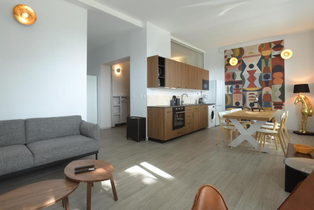 un salon et une cuisine avec un canapé et une table dans l'établissement Au Cheval Blanc - Appartement Familial 6P Parking privé proche Colmar Centre, à Colmar