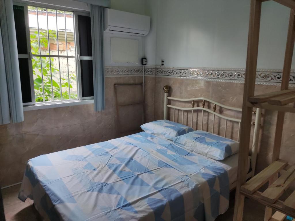 a bedroom with a bed and two windows at Entre a paz e o canto dos pássaros in Manaus