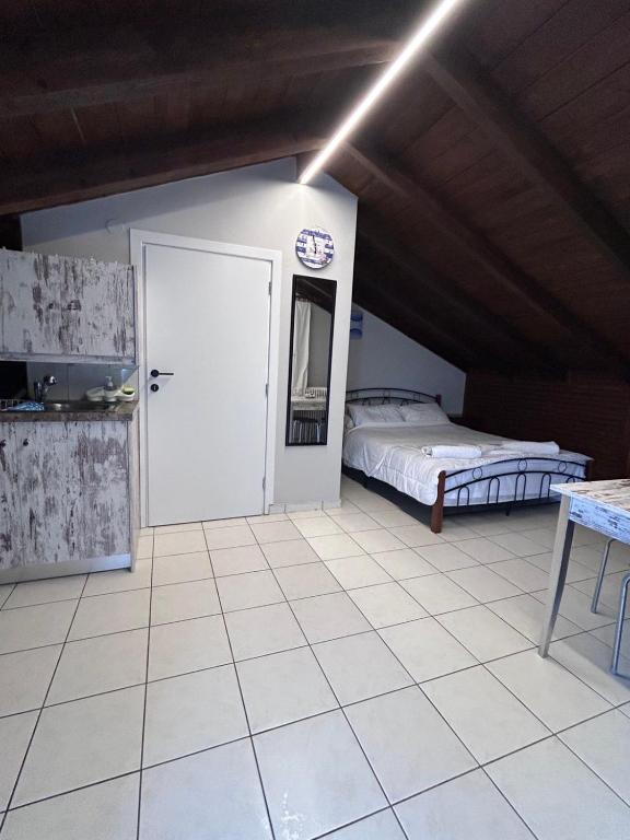 sypialnia z łóżkiem i białą podłogą wyłożoną kafelkami w obiekcie Lazarus Beach Sofitas w mieście Monemwasia