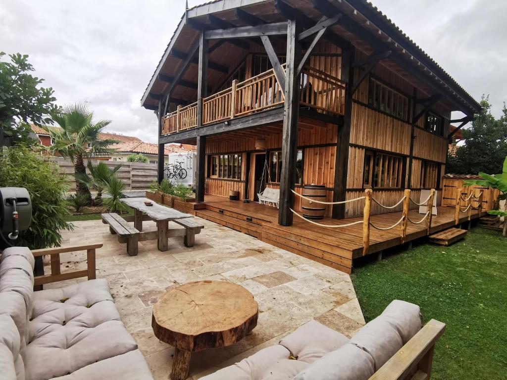 un grand bâtiment en bois avec une table et des bancs dans l'établissement Maison bois, entre ville et lac, à Lacanau