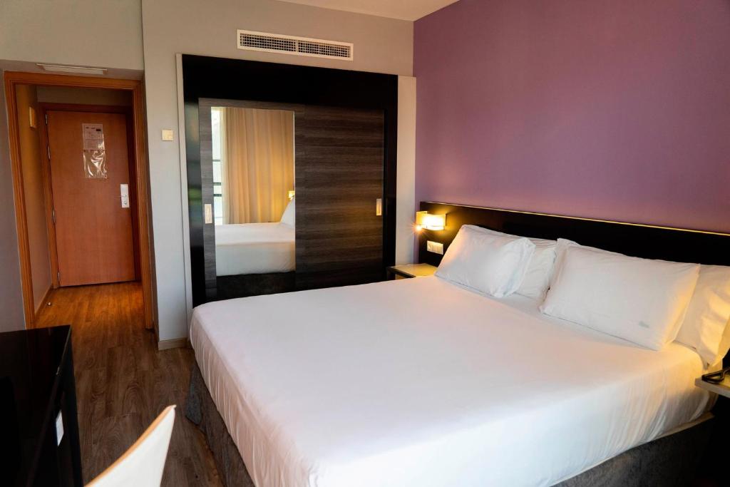 Postel nebo postele na pokoji v ubytování Sercotel Córdoba Medina Azahara