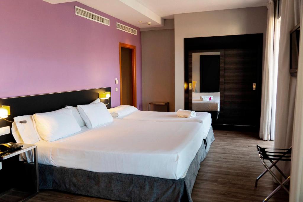 Postel nebo postele na pokoji v ubytování Sercotel Córdoba Medina Azahara