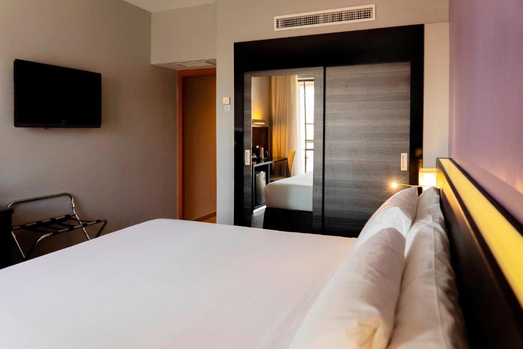Postel nebo postele na pokoji v ubytování Sercotel Córdoba Medina Azahara