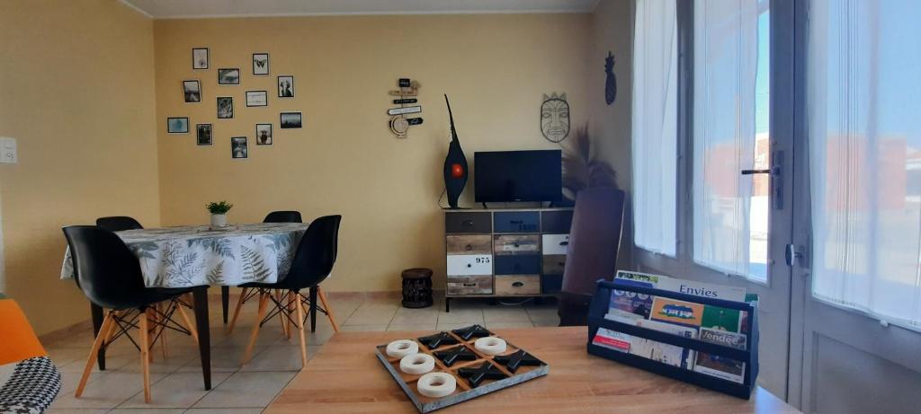 a dining room with a table and chairs and a window at Ma maison au bord de la mer in Saint-Hilaire-de-Riez