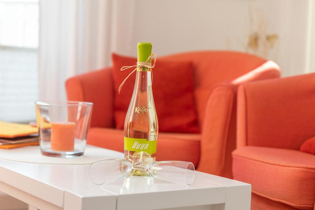 a bottle of wine sitting on a table with a glass at Godeke Michels Ferienwohnung 23-Jonggöntje Seestr5b in Groß Kirr