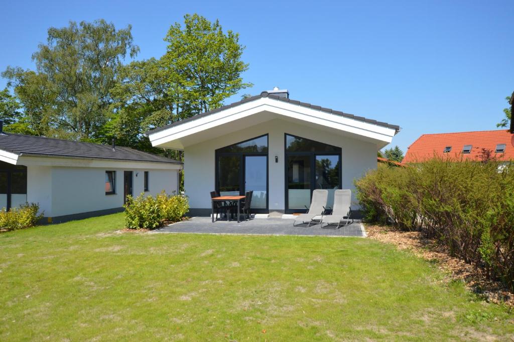 a house with a patio and a table and chairs at Gartenhaus 2, inkl 1 Parkplatz in Fehmarn