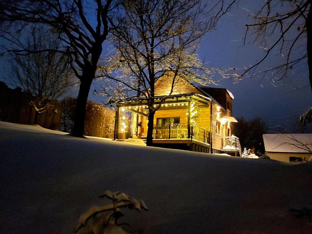 a house covered in lights in the snow at night at LOFT WAPITI in Hutisko