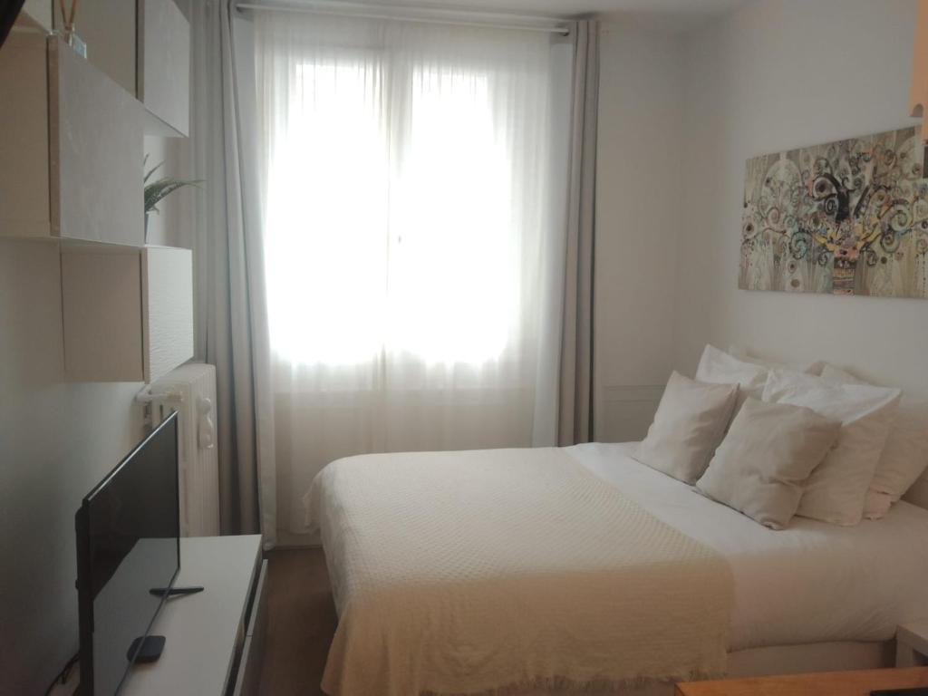 une chambre avec un lit blanc et une fenêtre dans l'établissement Beautiful stay in Paris, à Paris