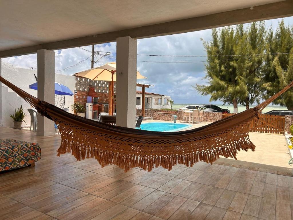 a hammock in a house with a pool at Martinelli Residence Beira Mar I e II in Itamaracá