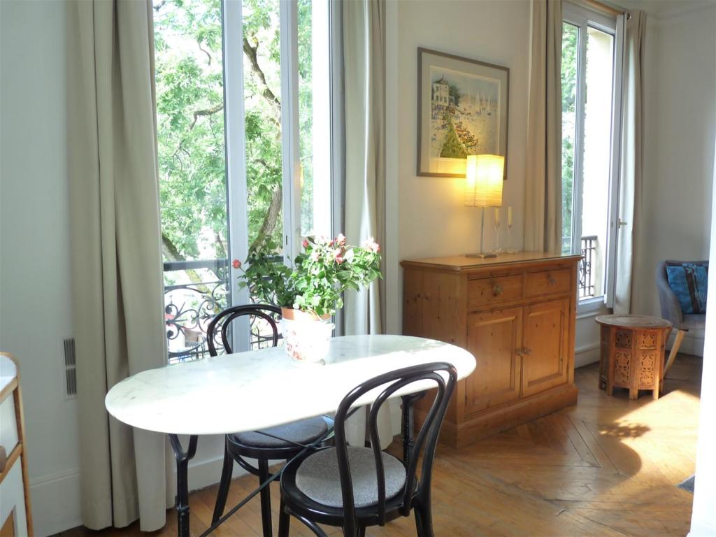 une salle à manger avec une table et des chaises et une fenêtre dans l'établissement Le Alesia, à Paris