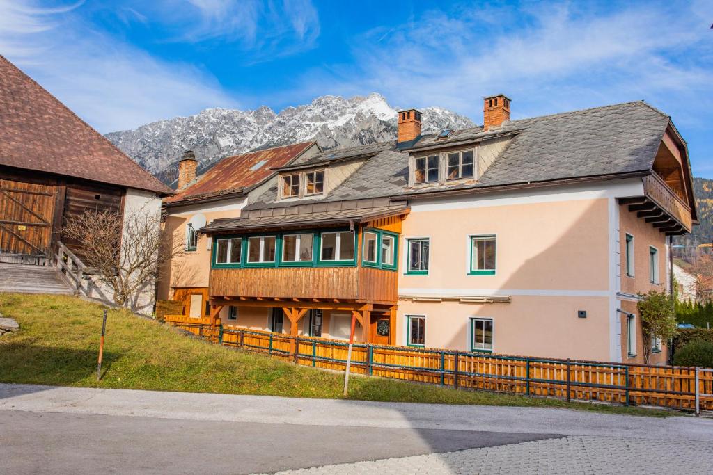 a large white house with a wooden fence at Hoamathaus II by Alpenidyll Apartments in Gröbming