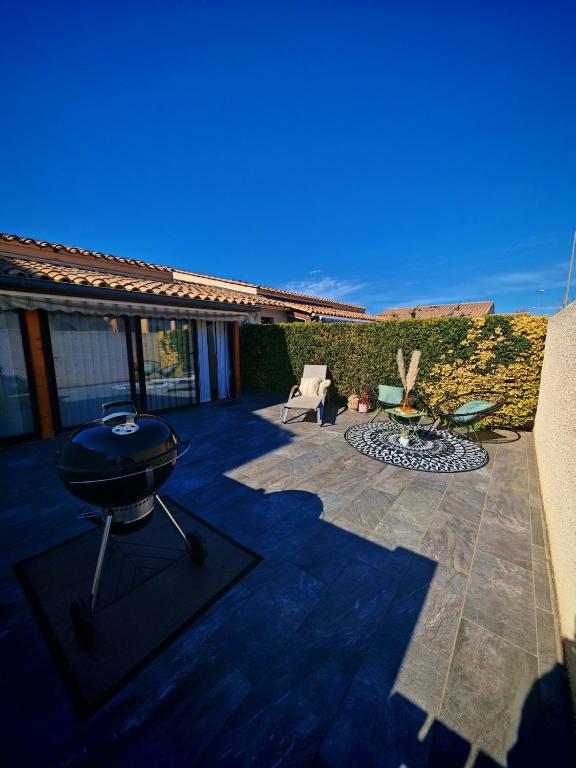 une arrière-cour avec un barbecue et un foyer extérieur dans l'établissement Villa à 300m de la plage Richelieu, au Cap d'Agde