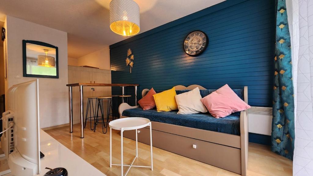 Cette chambre comprend un lit avec des oreillers colorés. dans l'établissement apartement 3 pieces avec piscine chauffée, à La Foux d'Allos