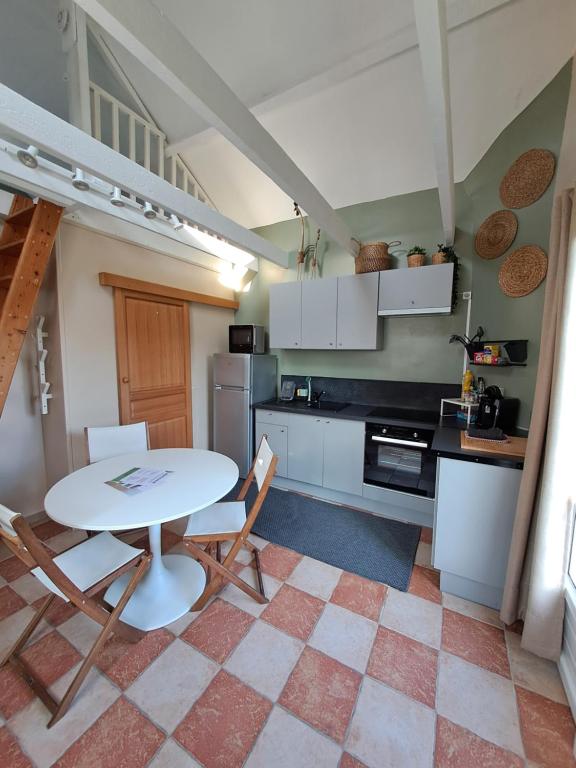 une cuisine avec une table et des chaises dans une pièce dans l'établissement Gîte des Près, à Verton