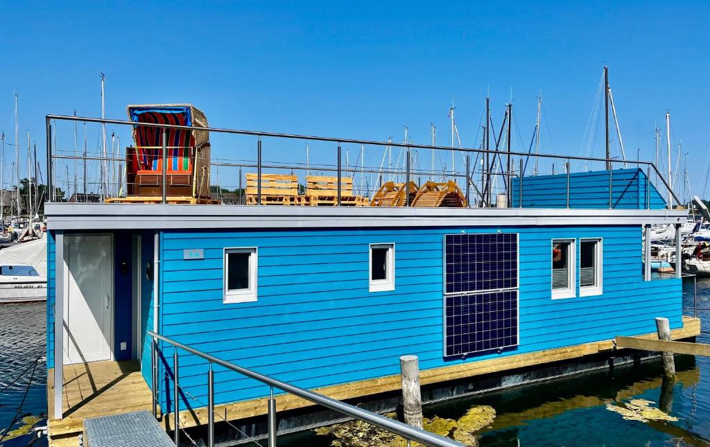 een blauw huis bovenop een steiger bij Hausboot Isa - Huus & Meer in Großenbrode-Kai