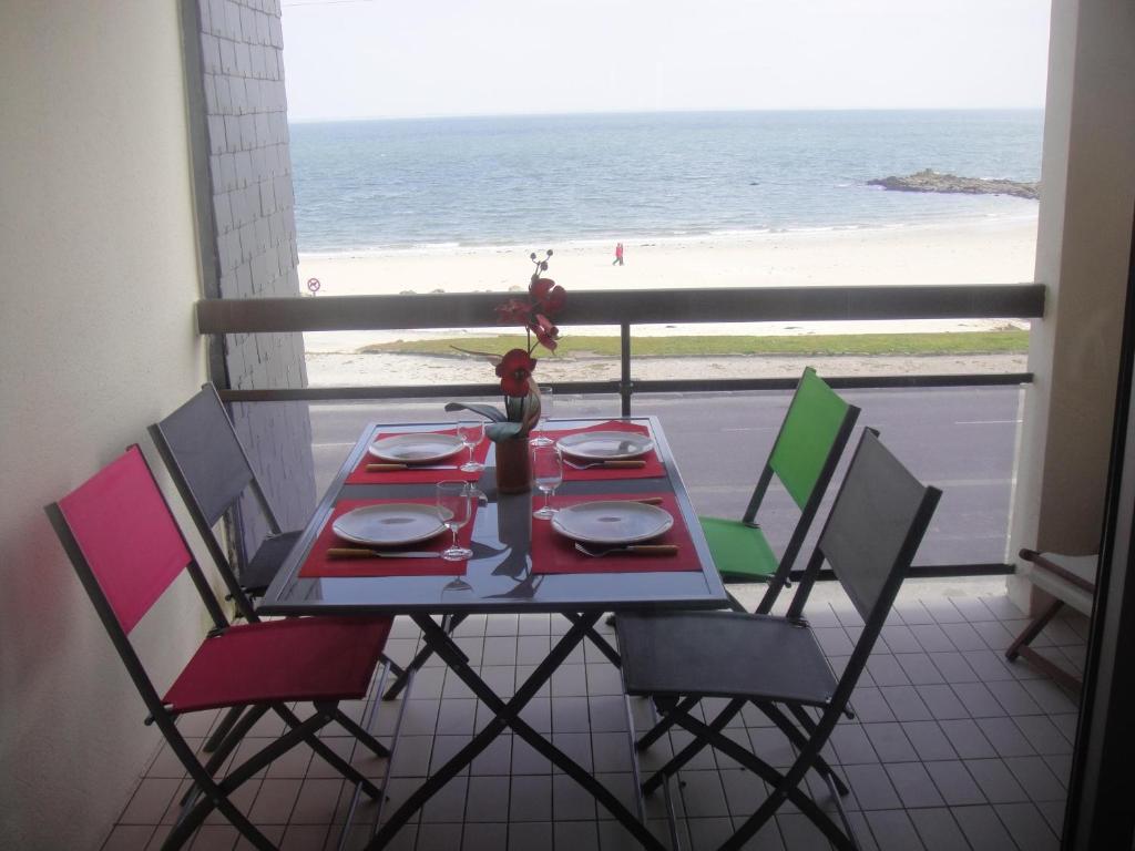 a table and chairs with a view of the beach at Residence Front De Mer in Quiberon