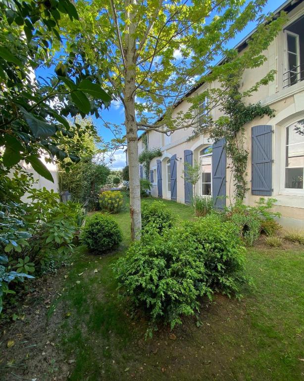 une maison avec un arbre dans la cour dans l'établissement 2 Chambres, spéciales 24H DU MANS, au Mans