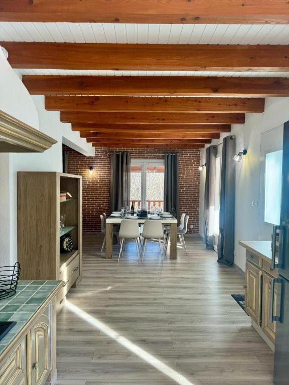 une cuisine et une salle à manger avec une table et des chaises dans l'établissement Maison Emilie, à La Bréole