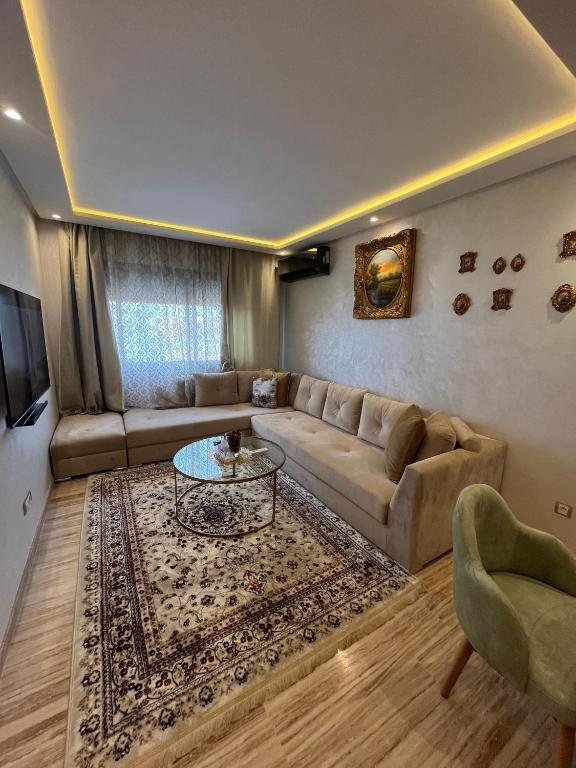 a living room with a couch and a table at Studio proche clinique akdital ain sebaa in Casablanca