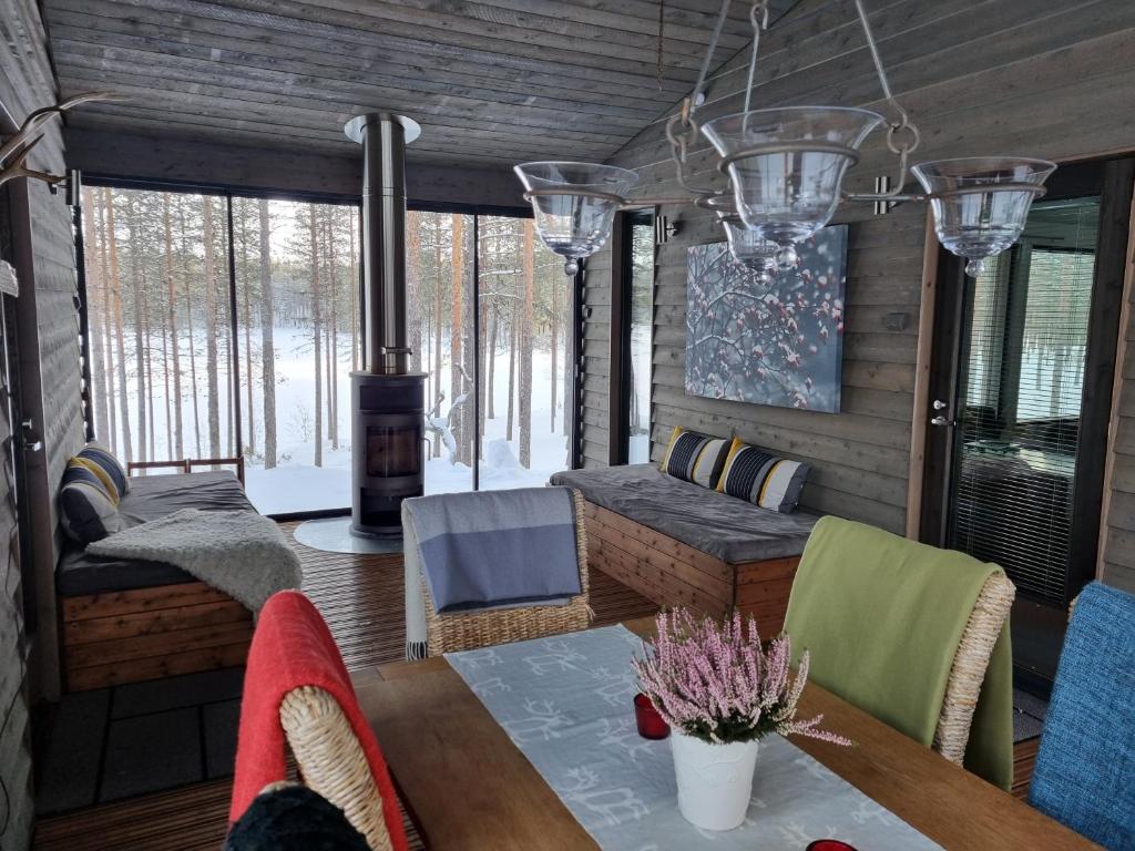 a living room with a table and a stove at Harjunranta in Kuusamo