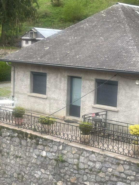 Cette maison dispose d'un balcon avec une table et des fenêtres. dans l'établissement Maison individuelle a Arreau, à Arreau
