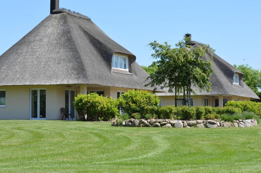 a house with a thatched roof and a yard at Reetdachhaus 3, inkl 2 Parkplätze in Fehmarn
