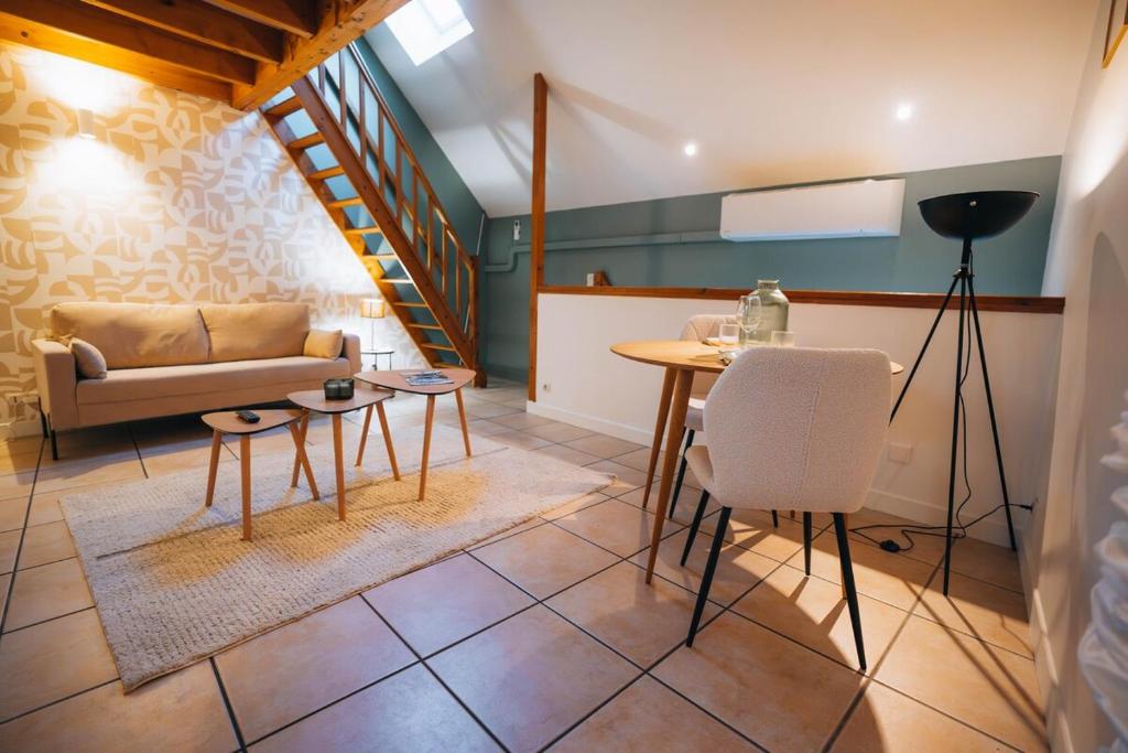una sala de estar con un sofá y una mesa en Le Perchoir - Duplex - Cozy & Atypical, en Châteauroux