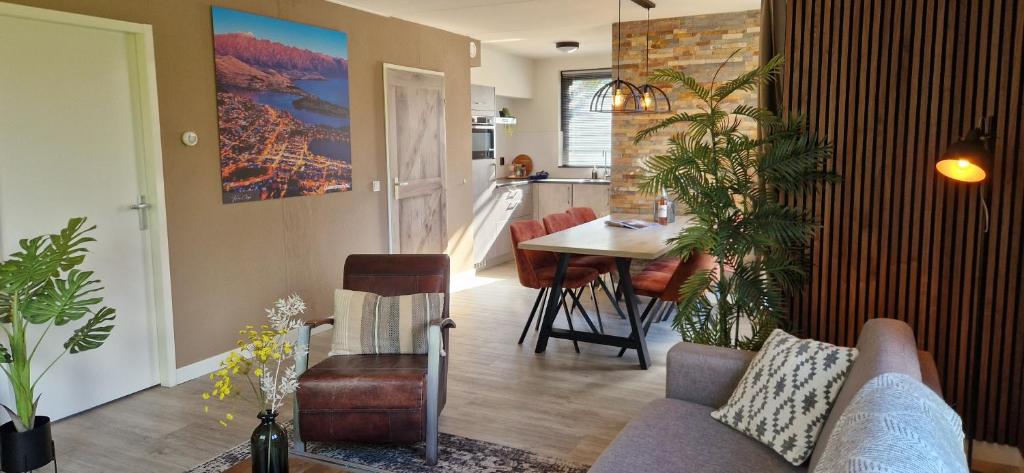 a living room with a couch and a table at Gezellig 6pers Familiehuis grote tuin met BBQ aan meer Gelderland in Ewijk